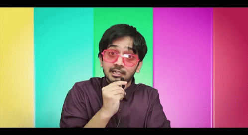 Man With Sunglasses and Beard Talking Into Microphone