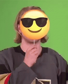 Man With Sunglasses and Smiley Mask Holding Lollipop