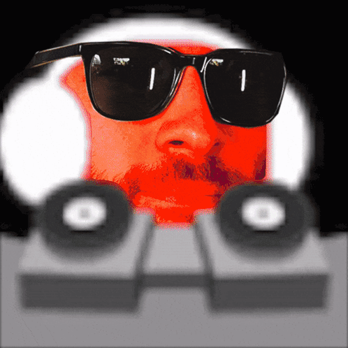 Man with Sunglasses Behind Speakers