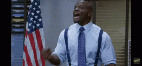 Man With Suspenders and Tie in Front of American Flag