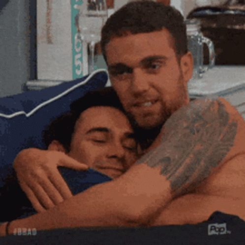 Man with Tattoo Hugging Another Man