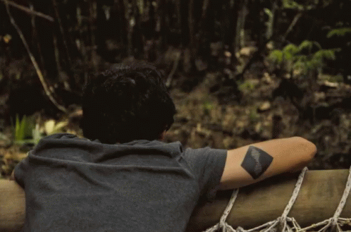Man With Tattoo Looking Over Railing GIF