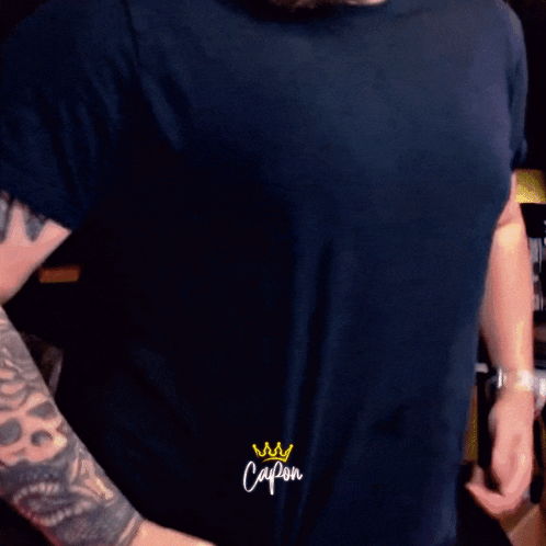 Man With Tattoo On Arm Saying Capon On Sleeve GIF