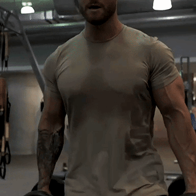 Man With Tattoo On Arm Standing In Gym GIF