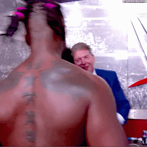 Man With Tattoo Talking To Suit GIF