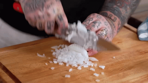 Man With Tattoos Cutting Onions on Wooden Cutting Board