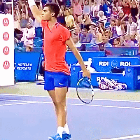 Man With Tennis Racquet In Front Of Hotel & Resorts Sign GIF