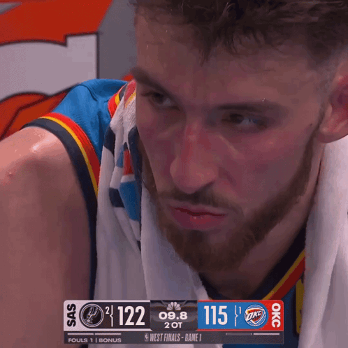 Man With Towel Looking at Scoreboard