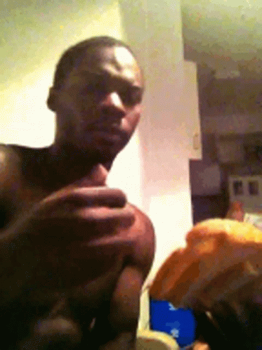 Man Without Shirt Holding Something in Kitchen