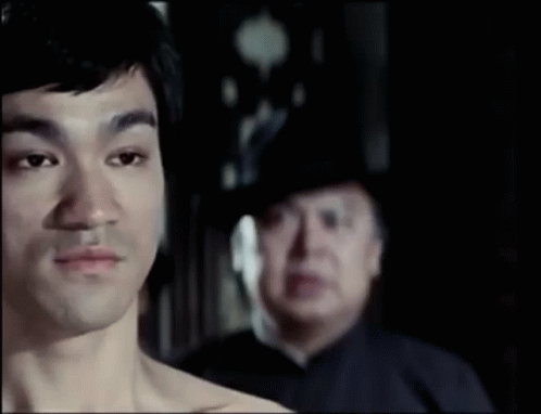 Man Without Shirt In Front Of Man In Hat GIF