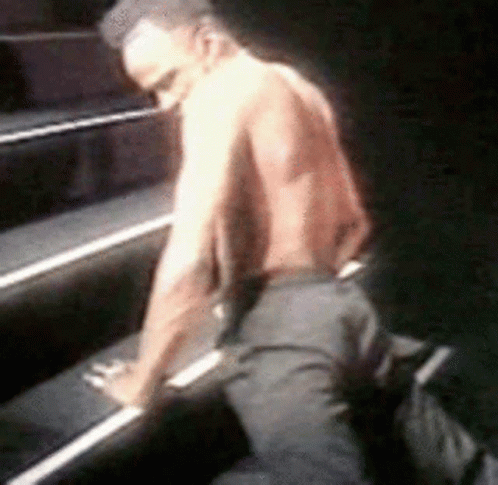 Man Without Shirt Kneeling on Piano