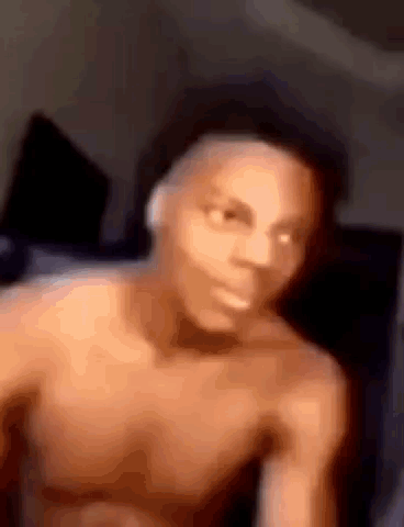 Man Without Shirt Sitting on Bed