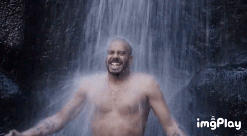 Man Without Shirt Smiling In Front Of Waterfall GIF