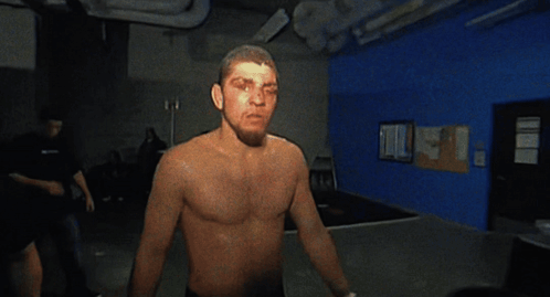 Man Without Shirt Standing in Dark Room