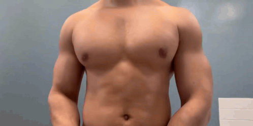 Man Without Shirt Standing in Front of Blue Wall