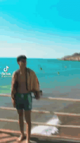 Man Without Shirt Standing On Dock GIF