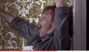 Man Yawning in Front of Floral Wallpaper