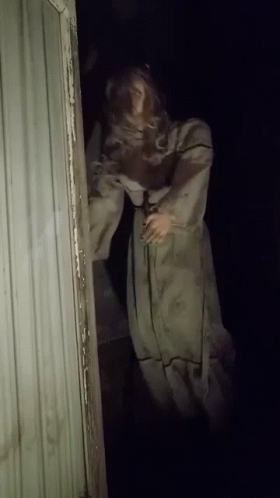 Mannequin in White Dress in Dark Doorway