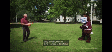 Mascot Costume Talking to Man in Red Shirt