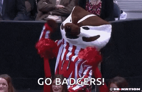Mascot in Red and White Striped Shirt Held Up by Cheerleaders