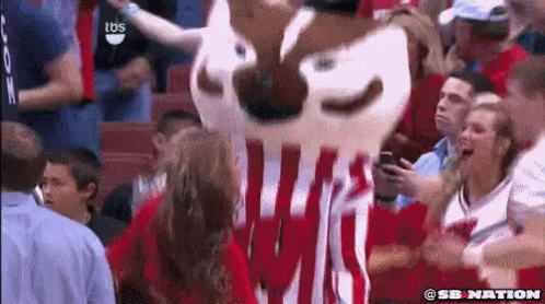 Mascot in Red and White Striped Shirt Standing in Crowd