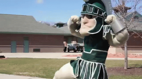 Mascot in Spartan Costume in Front of Brick Building