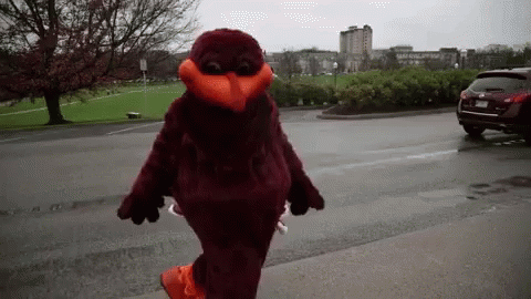 Mascot Walking Down Street in Front of Parking Lot