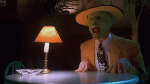 Masked Man At Table With Orange Lamp GIF