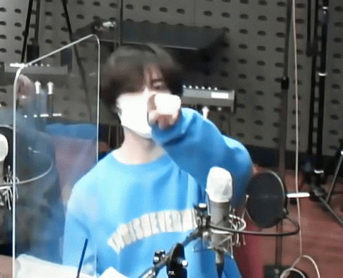 Masked Man in Blue Sweater at Microphone