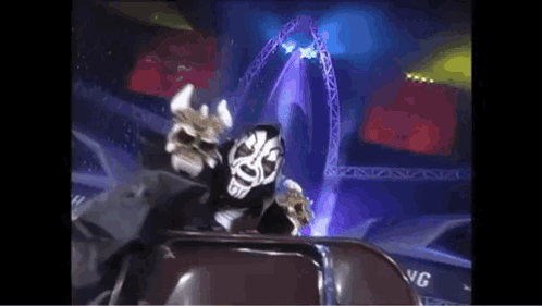 Masked Man Sitting in Stadium With Stage