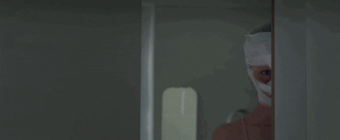 Masked Man Stalking Behind Wall GIF