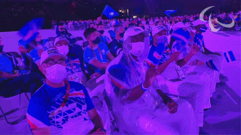 Masked People Sitting in Purple Lit Stadium
