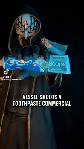 Masked Person Holding Crest Toothpaste