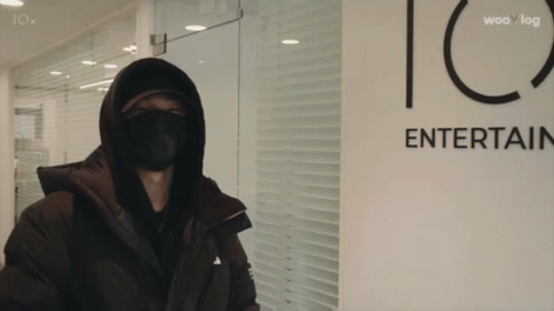 Masked Person in Front of Iox Entertainment Sign