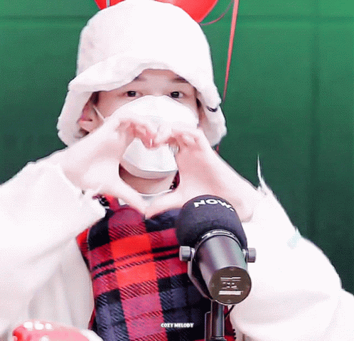 Masked Person Making Heart Beside Cozy Melody Microphone