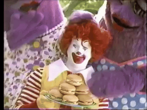 McDonald's Clown Holding Plate of Hamburgers in Front of Purple Monster