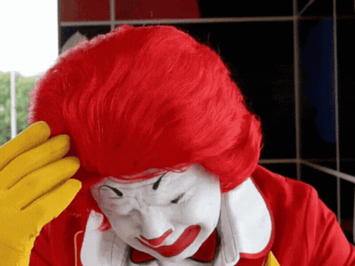 McDonald's Clown Scratching Head With Red Hair and Yellow Gloves