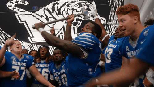 Memphis Football Players Holding Stick in Air