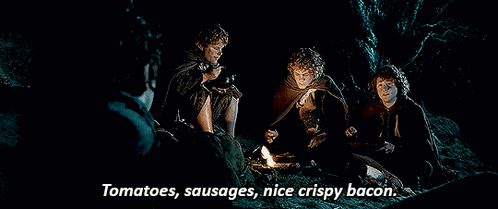 Men Around Campfire Eating Tomatoes Sausages Bacon
