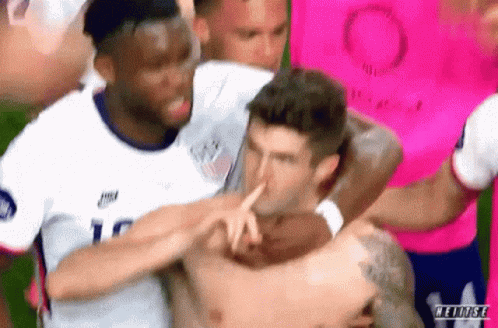 Men Around Shirtless Soccer Player Pointing At Nose GIF