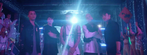 Men Dancing On Stage In Front Of Devil's Building GIF