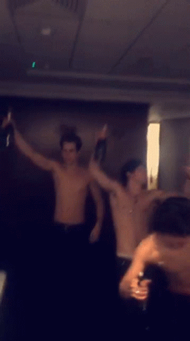 Men Dancing Shirtless in Dark Room