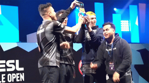 Men Holding Trophy In Front Of ESL Logo GIF