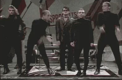 Men in Black Jumpsuits Dancing on Stage