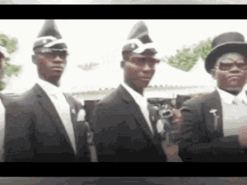 Men In Black Suits And Hats Standing Together GIF