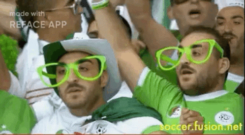 Men In Green Glasses And Hats Watching Soccer GIF