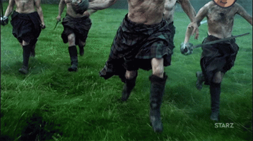 Men in Kilts Running in Grassy Field with Starz