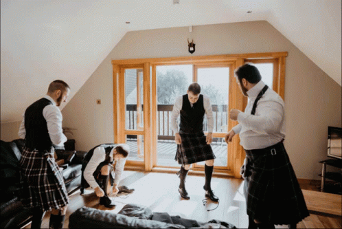 Men in Kilts Standing in Living Room
