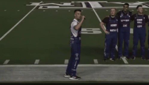 Men in Overalls Saying Good Bull on Football Field
