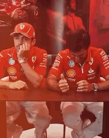 Men in Red Ferrari Shirts Sitting at Table